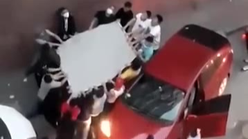 居民楼失火男子逃生欲跳楼,群众抬车撑被子救人